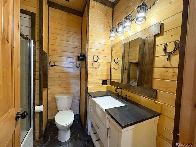 bathroom featuring toilet, wooden walls, and vanity