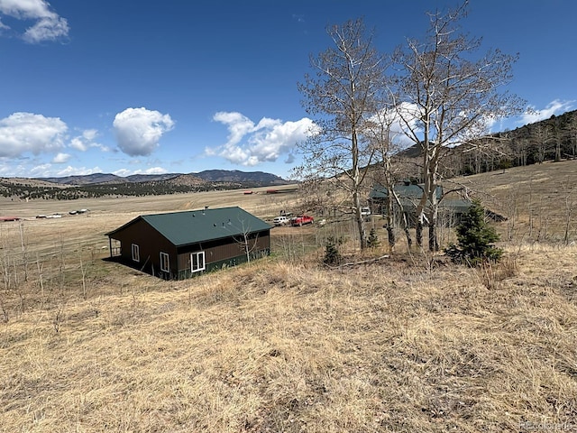 exterior space featuring a mountain view, an outbuilding, and a rural view
