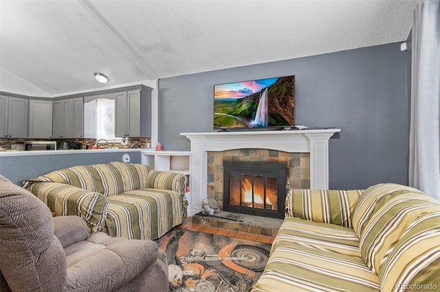9648 Lane St, Thornton, CO 80260 - living room featuring vaulted ceiling, a fireplace, and wood finished floors