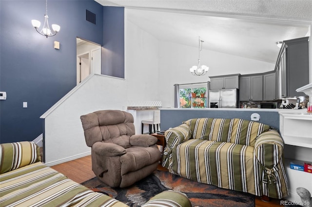 9648 Lane St, Thornton, CO 80260 - living area featuring a chandelier, wood finished floors, and high vaulted ceiling