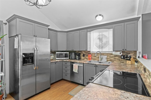 9648 Lane St, Thornton, CO 80260 - kitchen featuring stainless steel appliances, gray cabinetry, lofted ceiling, and tasteful backsplash