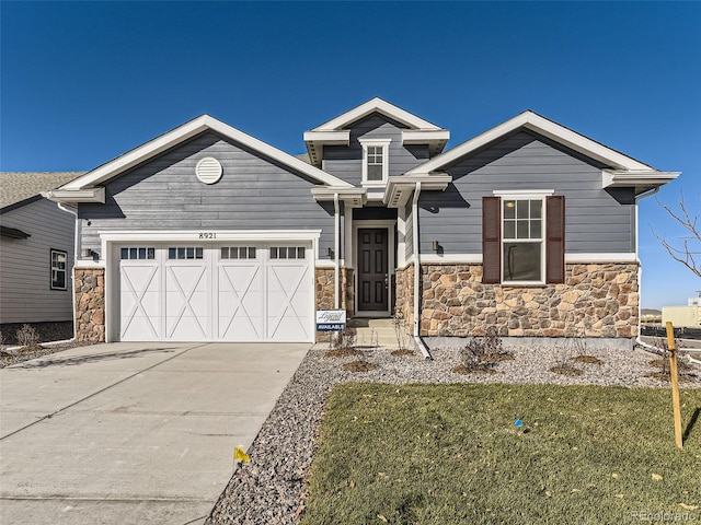 craftsman house with a garage and a front lawn