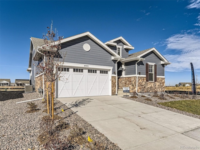 view of front of property featuring central AC unit and a garage