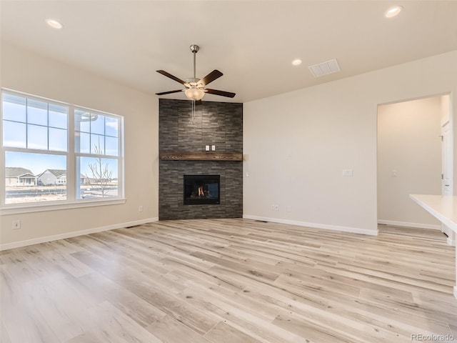 unfurnished living room with a fireplace, light hardwood / wood-style floors, and ceiling fan