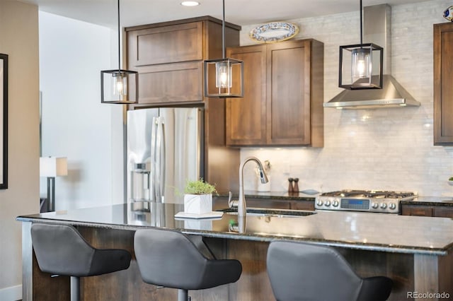 1882 W 67th Ave, Denver, CO 80221 - kitchen featuring appliances with stainless steel finishes, wall chimney range hood, pendant lighting, tasteful backsplash, and recessed lighting