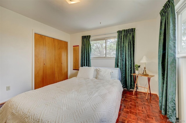 bedroom featuring dark parquet floors and a closet