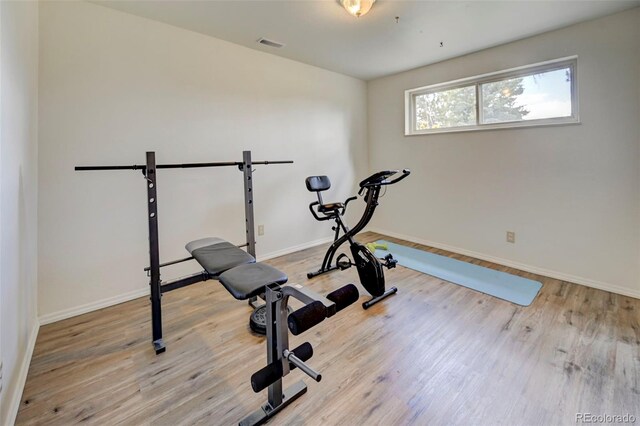 workout area with light hardwood / wood-style flooring