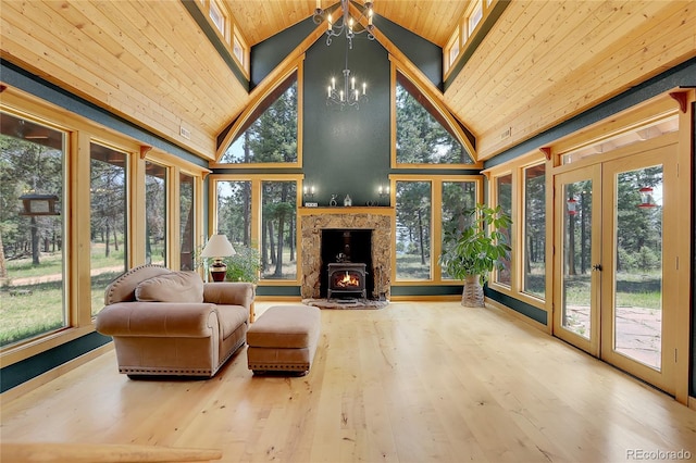 sunroom / solarium with lofted ceiling, wooden ceiling, french doors, and an inviting chandelier