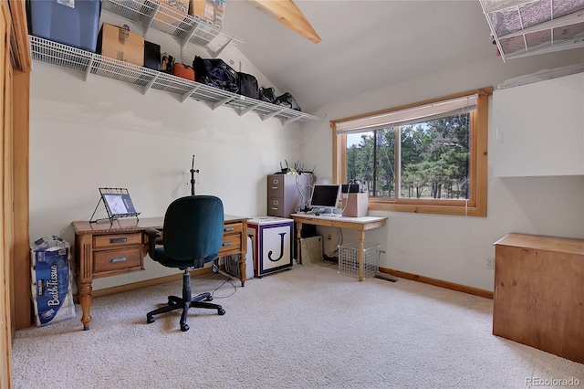 home office with lofted ceiling, light carpet, and baseboards