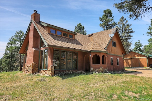 26526 Gray Buck Trl, Conifer, CO 80433 - view of front facade featuring a chimney, roof with shingles, a front yard, and stone siding
