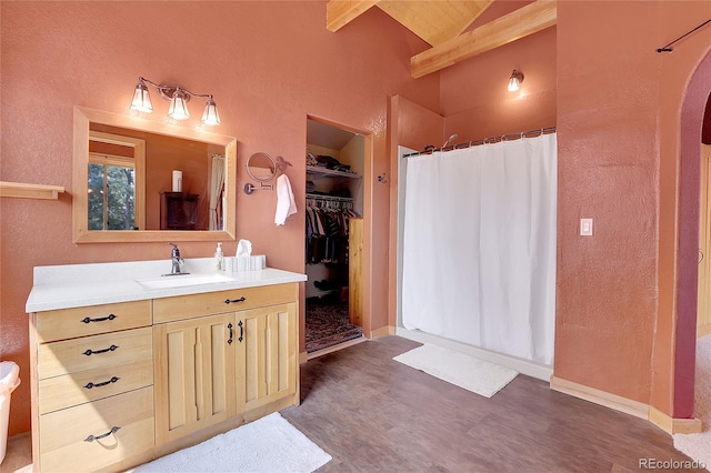 26526 Gray Buck Trl, Conifer, CO 80433 - full bath with wood finished floors, curtained shower, beamed ceiling, high vaulted ceiling, and vanity