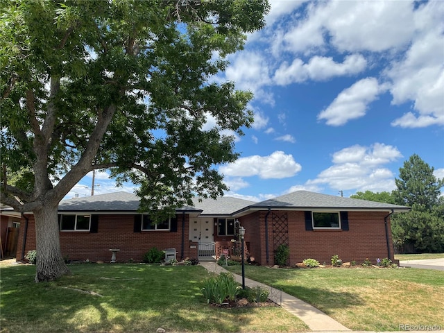 ranch-style home with brick siding and a front yard