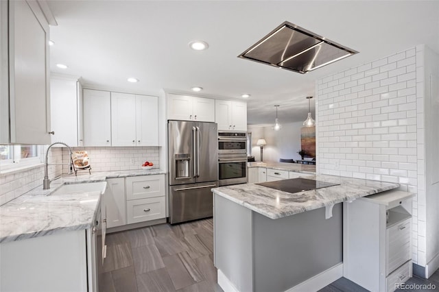 kitchen with a sink, tasteful backsplash, stainless steel appliances, a peninsula, and white cabinets