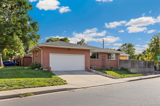 view of front of house with brick siding, fence, a front yard, a garage, and driveway