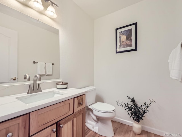 bathroom with vanity, toilet, and wood-type flooring