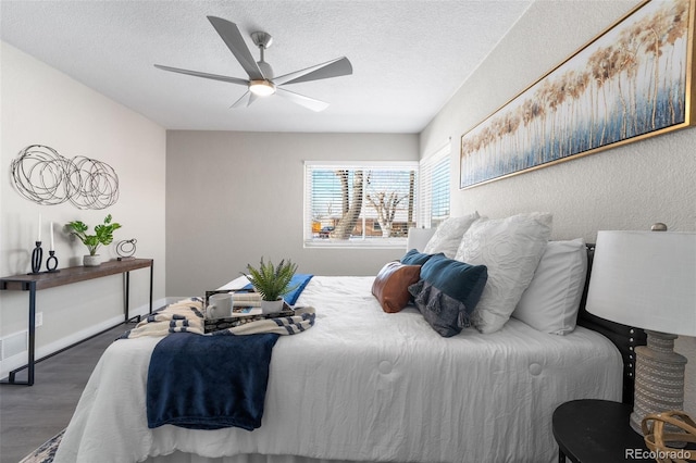 bedroom with a textured ceiling, wood finished floors, a ceiling fan, and baseboards