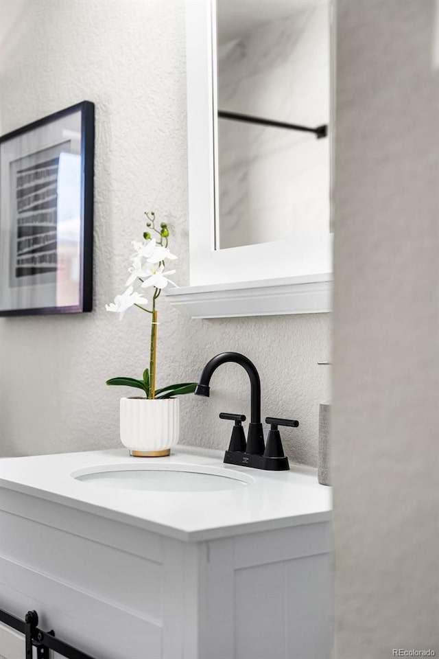 bathroom with vanity and a textured wall