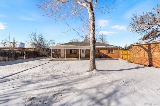 back of property with fence and brick siding