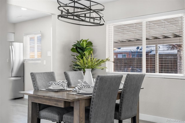 dining area with baseboards and a notable chandelier