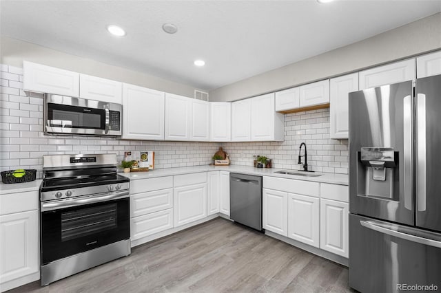 kitchen with visible vents, appliances with stainless steel finishes, light countertops, and a sink