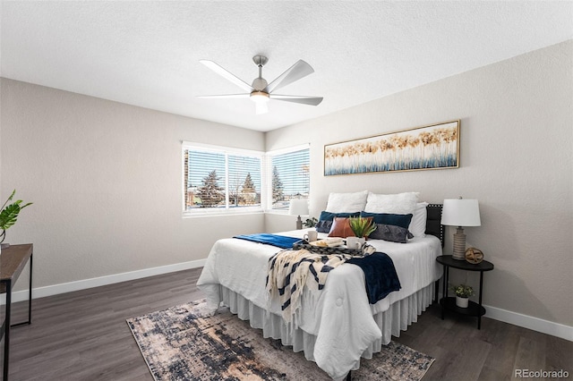 bedroom featuring ceiling fan, a textured ceiling, wood finished floors, and baseboards