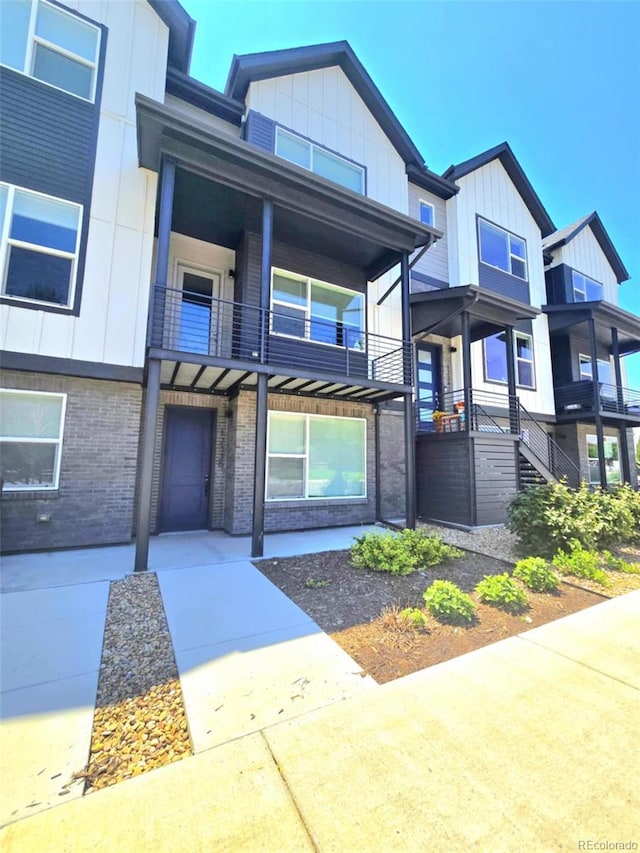 12336 W 52nd Ave, Wheat Ridge, CO 80033 - view of front facade with a balcony, brick siding, and board and batten siding