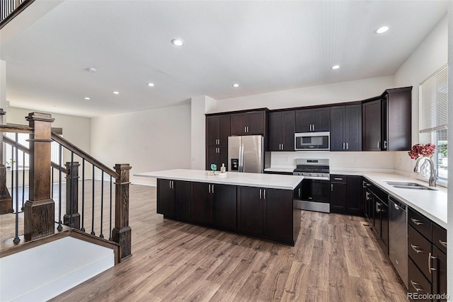 12336 W 52nd Ave, Wheat Ridge, CO 80033 - kitchen featuring stainless steel appliances, a kitchen island, light wood-style flooring, light countertops, and recessed lighting