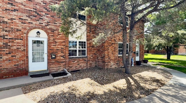 3616 W Radcliff Ave, Denver, CO 80236 - doorway to property featuring brick siding and a yard
