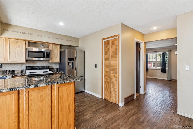 3616 W Radcliff Ave, Denver, CO 80236 - kitchen featuring stainless steel appliances, a textured ceiling, dark wood-style flooring, dark stone countertops, and baseboards
