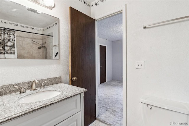 3616 W Radcliff Ave, Denver, CO 80236 - bathroom featuring a textured ceiling, vanity, toilet, and a shower