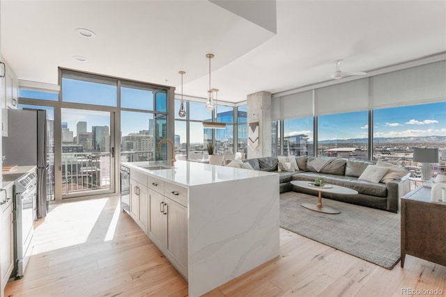 kitchen with a view of city, a wall of windows, open floor plan, and a sink