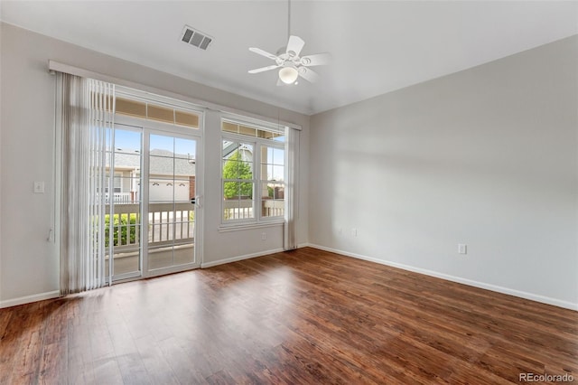 empty room featuring ceiling fan, baseboards, visible vents, and wood finished floors