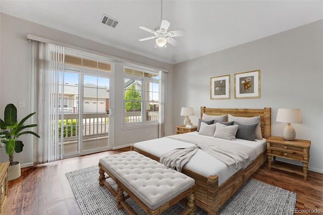 bedroom featuring access to exterior, baseboards, and wood finished floors