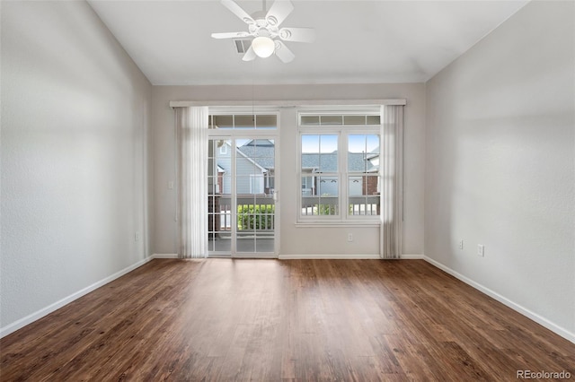 spare room featuring baseboards, wood finished floors, and ceiling fan