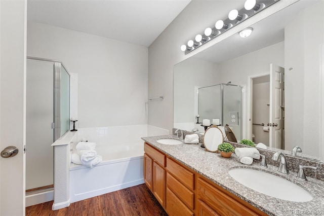 full bathroom featuring a shower stall, a garden tub, a sink, and wood finished floors