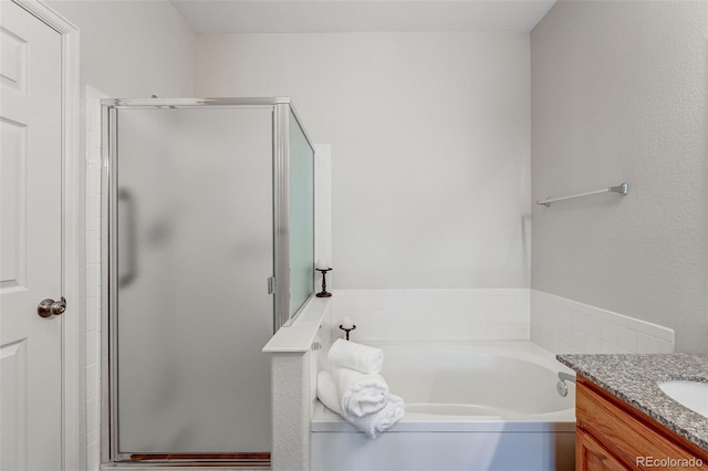full bathroom featuring a stall shower, a garden tub, and vanity