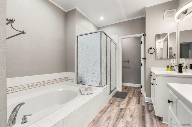 3818 S Dallas St, Aurora, CO 80014 - full bathroom featuring a shower stall, a garden tub, vanity, wood finished floors, and ornamental molding