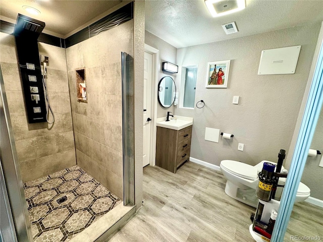 3818 S Dallas St, Aurora, CO 80014 - full bathroom featuring toilet, a shower stall, wood finished floors, and a textured ceiling