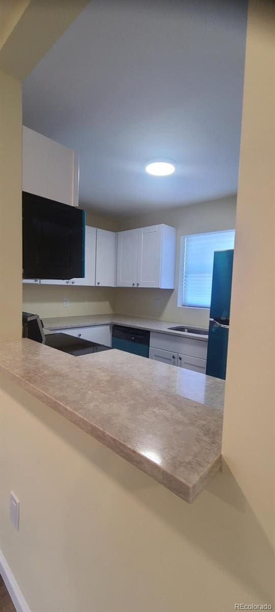 kitchen with white cabinetry, sink, and black appliances