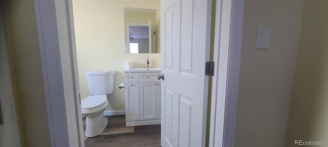 bathroom with hardwood / wood-style floors, vanity, and toilet