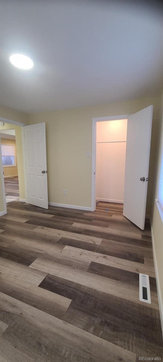 unfurnished room featuring dark wood-type flooring