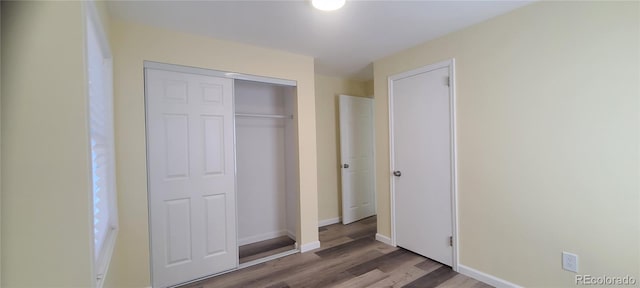 unfurnished bedroom with hardwood / wood-style floors and a closet