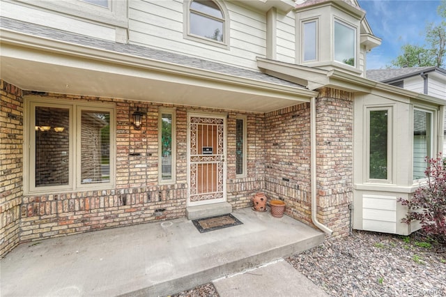 19149 E Ida Dr, Aurora, CO 80015 - doorway to property with covered porch, brick siding, and roof with shingles