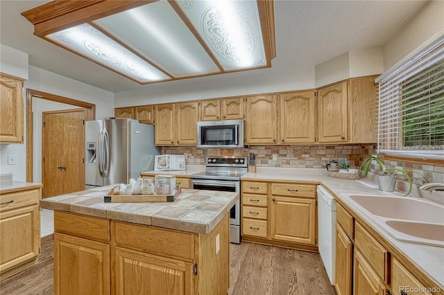 19149 E Ida Dr, Aurora, CO 80015 - kitchen featuring appliances with stainless steel finishes, light wood finished floors, a sink, and backsplash