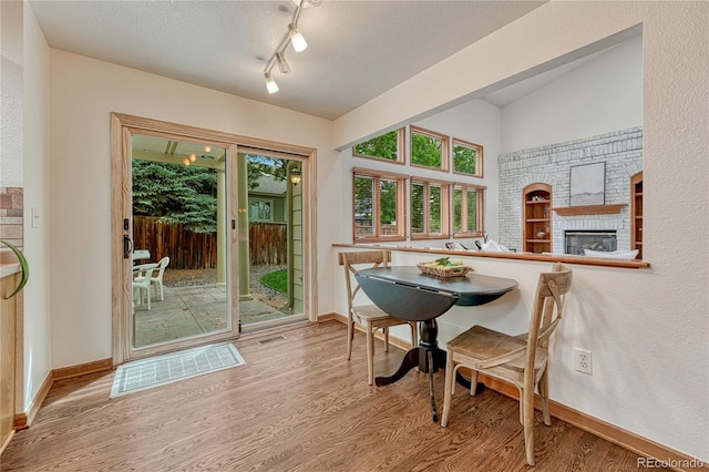 19149 E Ida Dr, Aurora, CO 80015 - dining space featuring wood finished floors, baseboards, and a brick fireplace
