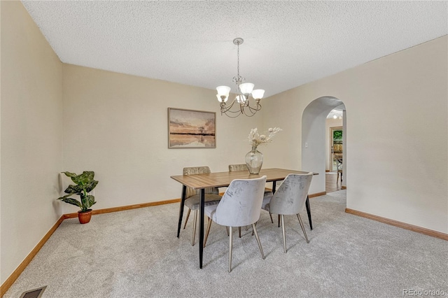 19149 E Ida Dr, Aurora, CO 80015 - dining area with arched walkways, light colored carpet, baseboards, and a textured ceiling