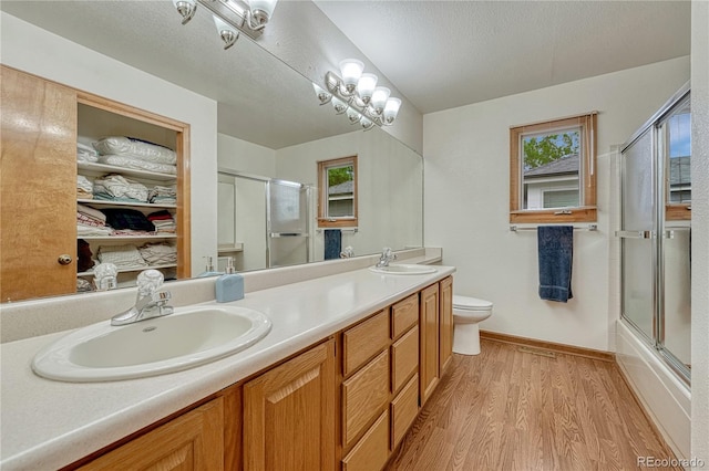 19149 E Ida Dr, Aurora, CO 80015 - bathroom with double vanity, toilet, baseboards, wood finished floors, and healthy amount of natural light
