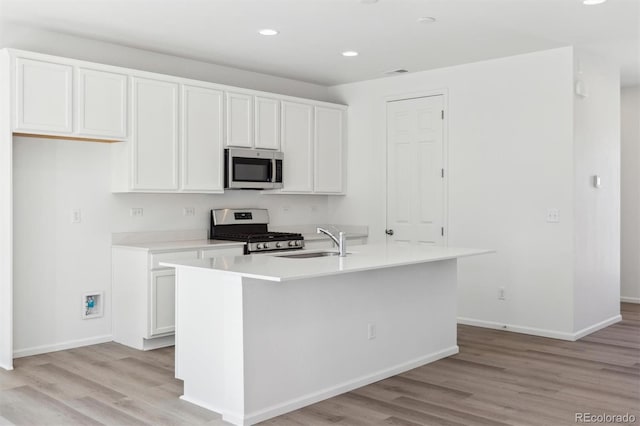 kitchen featuring white cabinetry, appliances with stainless steel finishes, sink, and a kitchen island with sink