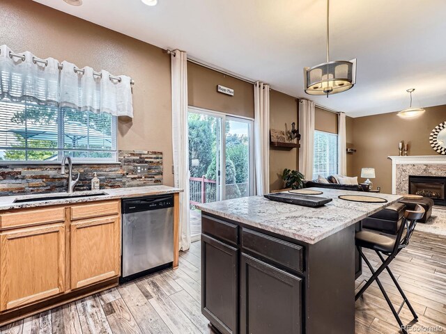9867 Mulberry Way, Highlands Ranch, CO 80129 - kitchen with stainless steel dishwasher, light wood-style flooring, a breakfast bar area, open floor plan, and pendant lighting