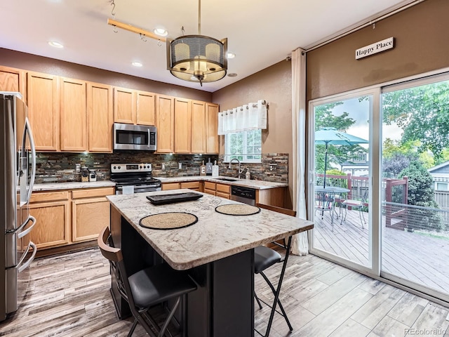 9867 Mulberry Way, Highlands Ranch, CO 80129 - kitchen featuring stainless steel appliances, a breakfast bar area, light wood-style flooring, light brown cabinets, and backsplash